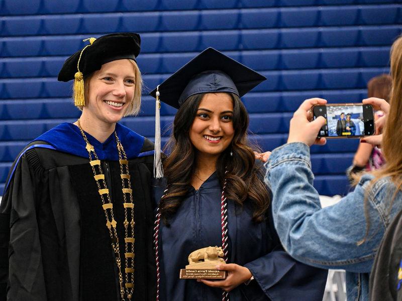 graduate and chancellor smiling for a photo